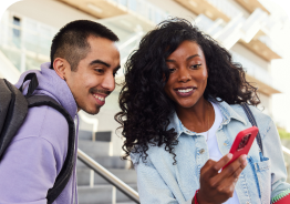 Two people standing next to each other smiling at a phone