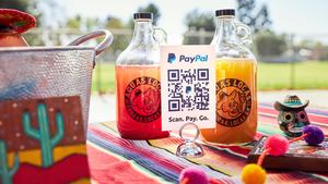 PayPal QR code on a sheet in front of two bottles of agua fresca.