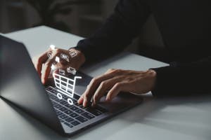 A man typing on his computer and searching for payment technology trends for his business.