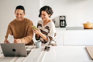 Man and woman laughing at a laptop