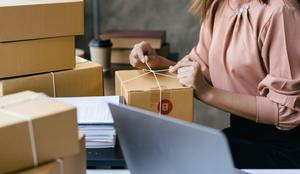 Female business owner preparing package for shipping