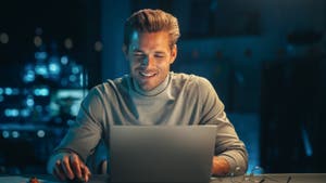 Male smiling at his laptop