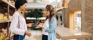 Woman using her phone to tap-to-pay in-store