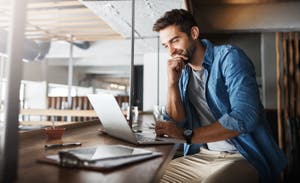 Male smiling at a laptop