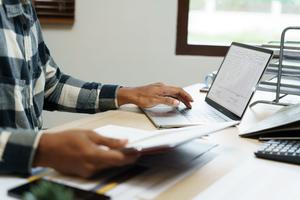 A guy working on his laptop and looking out ways to streamline checkout experiences at scale for his enterprise business.