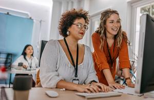 Female coworkers looking at a desktop computer