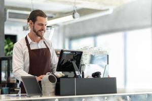 Small business owner working at the shop counter, considering starting a franchise.