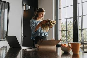 Girl unpacking a brown and yellow scarf received through online shopping at home.