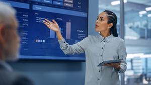 Woman presenting a sales forecast in front of a screen
