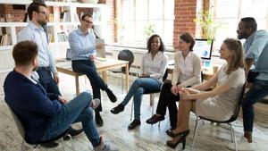 A mixed gender group of business people sitting in a circle and laughing