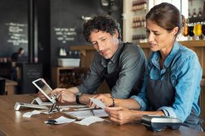 Two staff at a table calculating restaurant bill