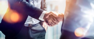 A close up of two men shaking hands