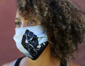 A girl with curly hair wearing a mask.