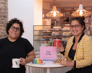 The two founders of Vida Bakery sitting together at a table in their store