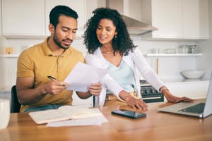 A couple reviews a document while updating their personal financial statement.