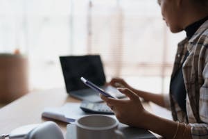 A woman types into her laptop and builds a budget calendar.