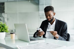 A man sharing his card information online via his mobile phone