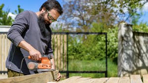 Image of man using a skill saw to cut wood