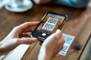 A woman makes a purchase using a QR code