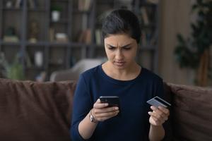 Distressed woman looking at her mobile phone