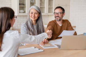 A middle-aged couple planning their finances with a professional