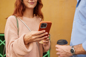 A man and woman holding a phone while standing next to each other.