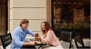 A man and woman sitting together at a table, enjoying each other's company in a friendly and relaxed setting.