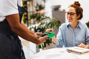 Customer in a cafe making contactless payment using smartphone