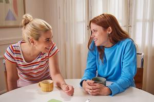 Two women sitting together at a table, deep in conversation.