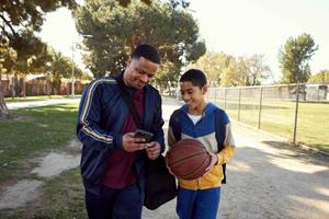 A father and son enjoying a friendly basketball game together on an outdoor court.