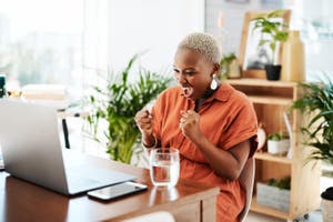 A woman joyous while looking at her laptop