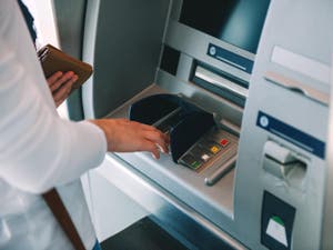 Woman using an ATM and keying in her PIN security number