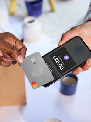 A customer pays for a purchase by tapping their Mastercard to a merchant's phone, which is equipped with Tap to Pay