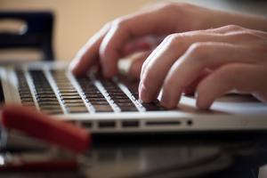 Close up of hands typing on a laptop.