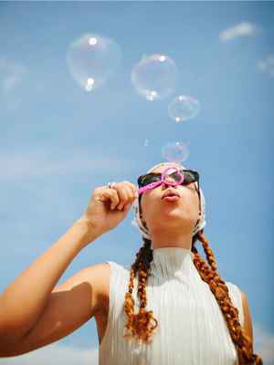 Woman blowing bubbles outside