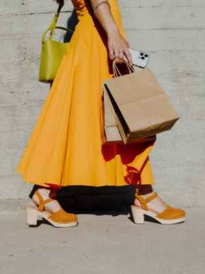 Woman in orange dress holding shopping bags