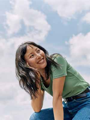 Woman in green t-shirt sitting outside