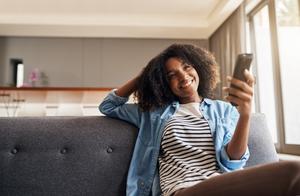 A woman turns on her TV to watch something on a subscription service.