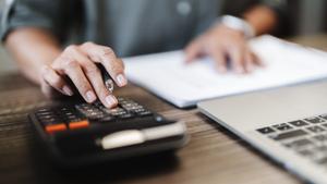 A woman calculates APY at her desk.