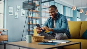 A man using mobile phone while sitting on sofa