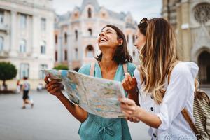 Two friends smile while looking at a map