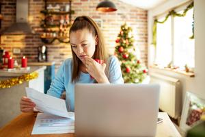 A woman builds a budget for the holidays on her laptop.