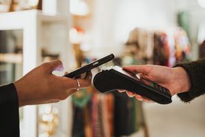 A person uses their digital wallet to make a payment in store.