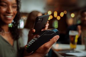 A woman makes a payment with the digital wallet on her phone.