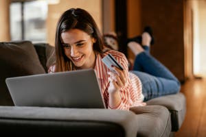 A woman shops online and pays using a cash back debit card