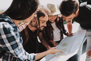 Friends look at a map while on vacation.